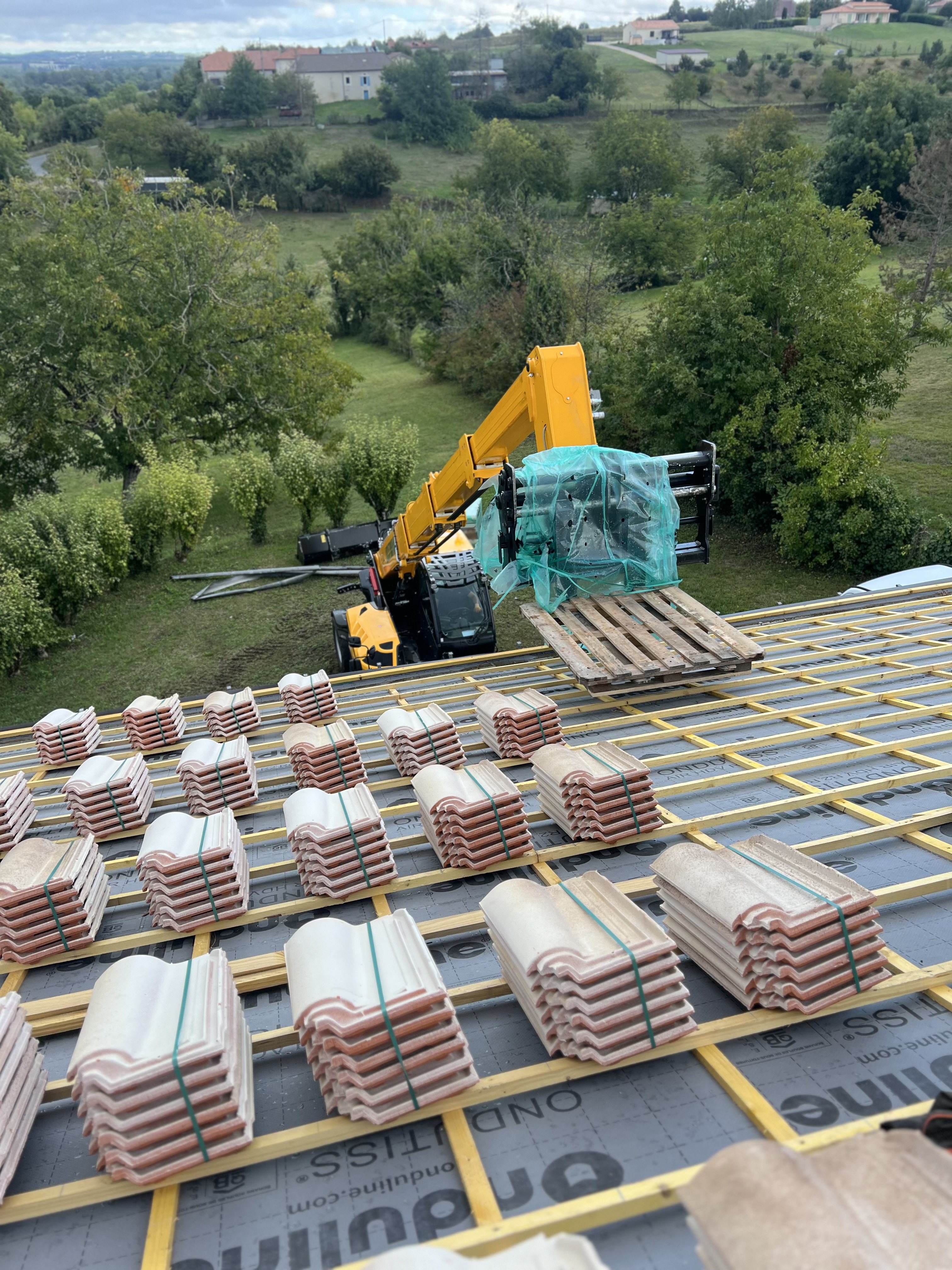 Livraison tuiles par grue chantier toiture Dordogne